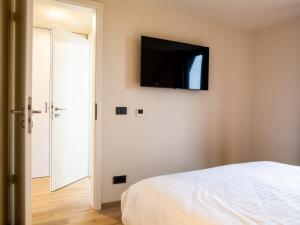 a bedroom with a bed and a flat screen tv on the wall at Vatra Barsei in Tohanu Nou