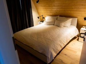 a bed with white sheets and pillows in a room at Vatra Barsei in Tohanu Nou