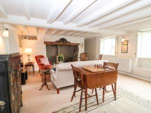 una sala de estar con una mesa de ajedrez en Holly Cottage en Minster Lovell