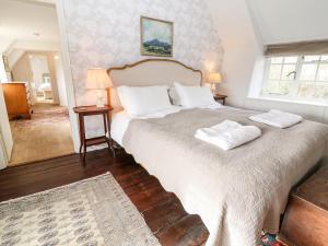 a bedroom with a large bed with two white pillows at Holly Cottage in Minster Lovell