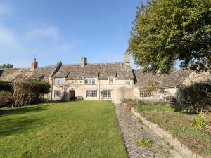 an old stone house with a large yard at Holly Cottage in Minster Lovell