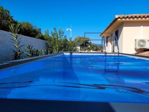 uma piscina azul em frente a uma casa em Villa Lagoon Solenzara em Togna