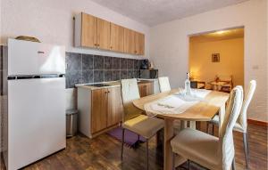 a kitchen with a table and a white refrigerator at Awesome Apartment In Premantura in Premantura +12 photos