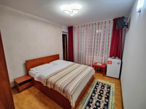 um pequeno quarto com uma cama e uma janela em Casa Adina em Sinaia
