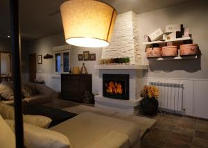 a living room with a fireplace and a couch at CASA RURAL "LA MAZA" entre encinas y dehesas in Terradillos