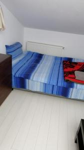 Un dormitorio con una cama con sábanas azules. en Fun Apartament Militari Residence, en Roşu