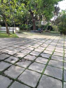 a stone patio with trees in a park at Mother's Inn Homestay in Cochin