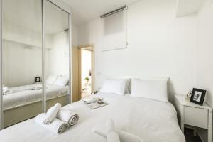 um quarto com uma grande cama branca e um espelho em Charming 1 BR Apt w Sliding Window in Tel Aviv by Sea N' Rent em Tel Aviv