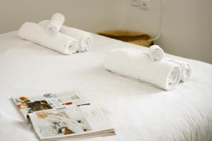 two rolled towels on a bed next to a magazine at Charming 1 BR Apt w Sliding Window in Tel Aviv by Sea N' Rent in Tel Aviv