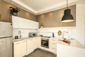 a kitchen with white cabinets and a black pendant light at Charming 1 BR Apt w Sliding Window in Tel Aviv by Sea N' Rent in Tel Aviv