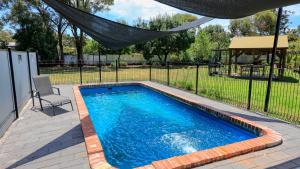 a swimming pool in a yard with a fence at Rose City Motor Inn in Benalla
