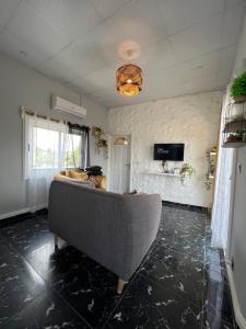 ein Wohnzimmer mit einem Sofa und einem TV in der Unterkunft Bel appartement avec petit balcon sympa in Porto-Novo