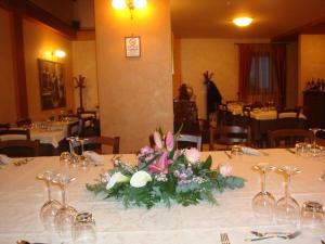 a table with a centerpiece of flowers and wine glasses at Affittacamere Al Cantoun in Chiomonte