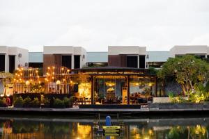 a building with lights in front of a body of water at Woda Villa & Spa in Sengkuang
