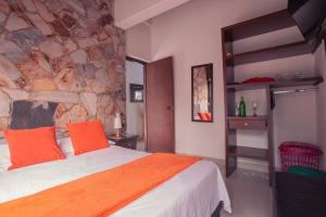 a bedroom with a bed and a stone wall at Hotel Palma De Sevilla in Medellín