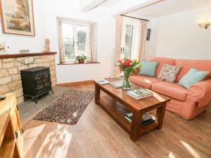 a living room with a couch and a fireplace at Cowfair Cottage in Chipping Campden
