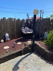 a garden with a swing in front of a fence at La Villa Citronnier in Petite Île