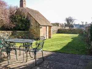 a table and chairs sitting on a patio at Cowfair Cottage in Chipping Campden