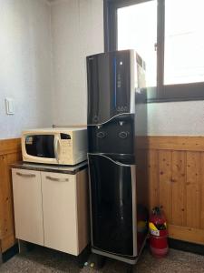 a kitchen with a microwave and a refrigerator at Sangmin Sweet in Daejeon