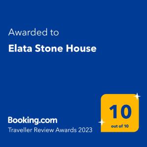 a yellow sign that says awarded to elia stone house at Elata Stone House in Eláta