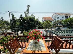 a table with a vase of flowers on a balcony at Thuy House Hoi An in Hoi An