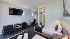 a hotel room with a bed and a desk and chairs at Rose City Motor Inn in Benalla