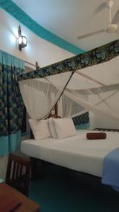 sypialnia z białym łóżkiem z baldachimem w obiekcie Warere Town House by Zanzibar Gem w mieście Zanzibar