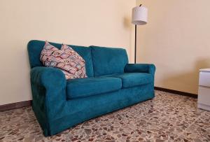 a blue couch with two pillows on it in a room at Giardino sul Naviglio in Milan +19 photos