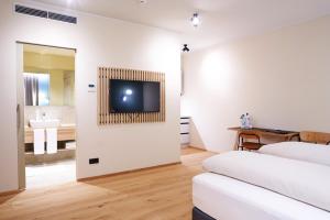 Zimmer mit 2 Betten und einem TV an der Wand in der Unterkunft Gasthof Maxlhaid in Wels