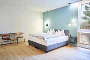 Schlafzimmer mit einem Bett, einem Schreibtisch und einem Tisch in der Unterkunft Gasthof Maxlhaid in Wels