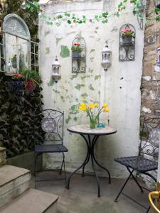Little Pinfold Cottage في سكيبتون: طاولة عليها كرسيين و مزهرية ورد