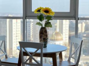 een tafel en stoelen met een vaas met een bloem erin bij Paris Evening in Chişinău