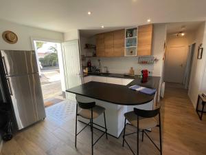 a kitchen with a black and white counter and a refrigerator at Maison avec spa idéalement placée au bois plage in Le Bois-Plage-en-Ré +10 photos