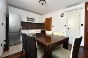 a kitchen with a wooden table and a refrigerator at Apartment Kokolo in Šibenik