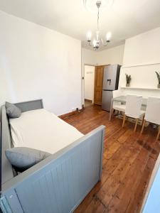 1 dormitorio con 1 cama, mesa y sillas en Spacious flat with patio garden en Raynes Park