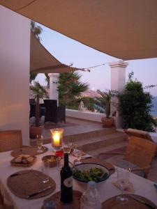 a table with a bottle of wine and a plate of food at Tranquil Villa with Sea view in Ammopi Karpathos in Amoopi
