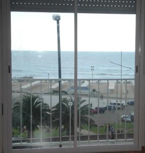 a window with a view of a beach and the ocean at Mar Del Plata Loft in Mar del Plata