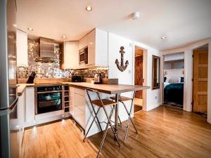 a kitchen with white cabinets and a island in it at Sandpearl Suite Apartments in Lytham St Annes