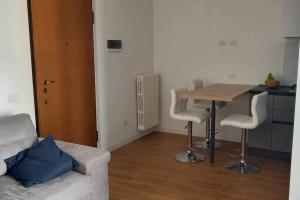 a living room with a table and chairs and a couch at Spilamberto 6b - 12mins from San Donato M3 station in San Donato Milanese