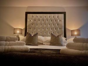 a bedroom with a bed with pillows and two lamps at Sandpearl Suite Apartments in Lytham St Annes