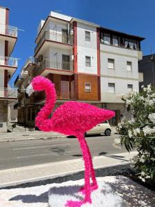 eine rosa Flamingo-Statue vor einem Gebäude in der Unterkunft Appart terrasse vue mer Tito in Margherita di Savoia
