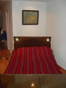 a bed with a red striped comforter in a room at Mar Del Plata Loft in Mar del Plata