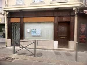 una tienda frente a un edificio con un cartel en la ventana en suite spa jacuzzi tout confort, en Beaumont-sur-Oise