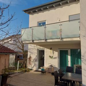 ein Haus mit einem Balkon mit einem Tisch und Stühlen in der Unterkunft Fewo.Gomaringen in Gomaringen