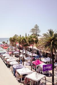 plaża z wieloma parasolami i palmami oraz oceanem w obiekcie Boardrider Backpackers and Budget Motel w mieście Sydney