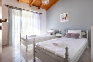 1 dormitorio con 2 camas y ventana grande en Villa Marianna, en Vryses