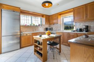 a kitchen with wooden cabinets and a stainless steel refrigerator at Villa Marianna in Vryses