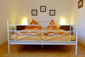 a white bed with orange pillows on it at heidel-home 3Raum Wohnung in Heidelberg