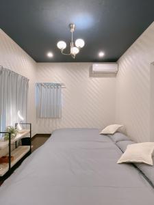 a bedroom with a large white bed with a ceiling at Alo BnB 2 - Near NIPPORI, SENDAGI, YANAKA GINZA - Self check-in in Tokyo