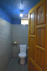 a bathroom with a toilet with a blue ceiling at H'mong Eco House in Lao Cai